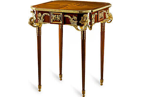 An astounding French Louis XVI style gilt-ormolu-mounted marquetry and veneer inlaid side table after the model “La Table Aux Muses” by Jean-Henri Riesener, executed later by François Linke, Paris, Circa 1900, Raised on handsome tapering fluted legs adorned with acanthus-cast sabots, ormolu floral chandelles and gilt-ormolu mottled capitals, At the top an elegant floral marquetry inlays in a different quarter veneers, all fitted within an ormolu fluted gallery, Extraordinary and high quality finely chased gilt ormolu mounts of acanthus volutes and C scrolls adorn the sides and corners of the frieze surrounding rectangular gilt-ormolu tablet decorated with finely chiseled ormolu high-relief depicting bacchanalian putti at play, The original table was supplied in 1771 for King Louis XVI's garde meuble. It was commissioned by Pierre-Elisabeth de Fontanieu, Intendant et Contrôleur général des Meubles de la Couronnefrom 1767-83, The cabinet work was made by Jean-Henri Riesener, maître in 1768, fournisseur du Garde Meuble de la Couronne from 1774 to 1784. The original is now in the permanent collection of the Musée de Versailles, on display at the Petit Trianon. 
